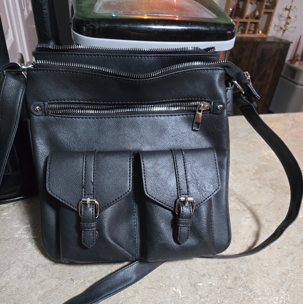 Black Cross Body Bag With Silver Zippers And Buckles.